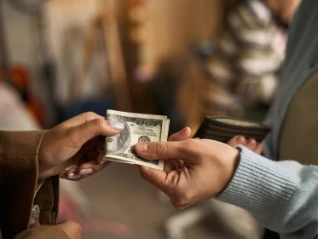 customer handing over cash to business owner