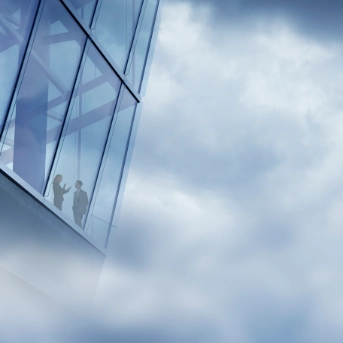 Two international workers in a high rise glass office