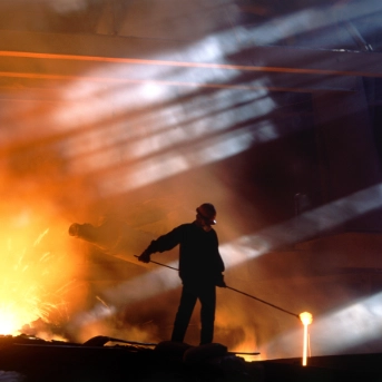 Smelting worker moving ore in landscape shot