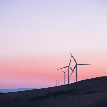 Wind turbines on a hillside at dusk