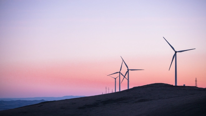 Wind turbines on a hillside at dusk