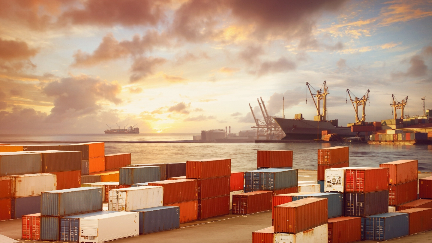 Shipping containers stacked up with sea in the background